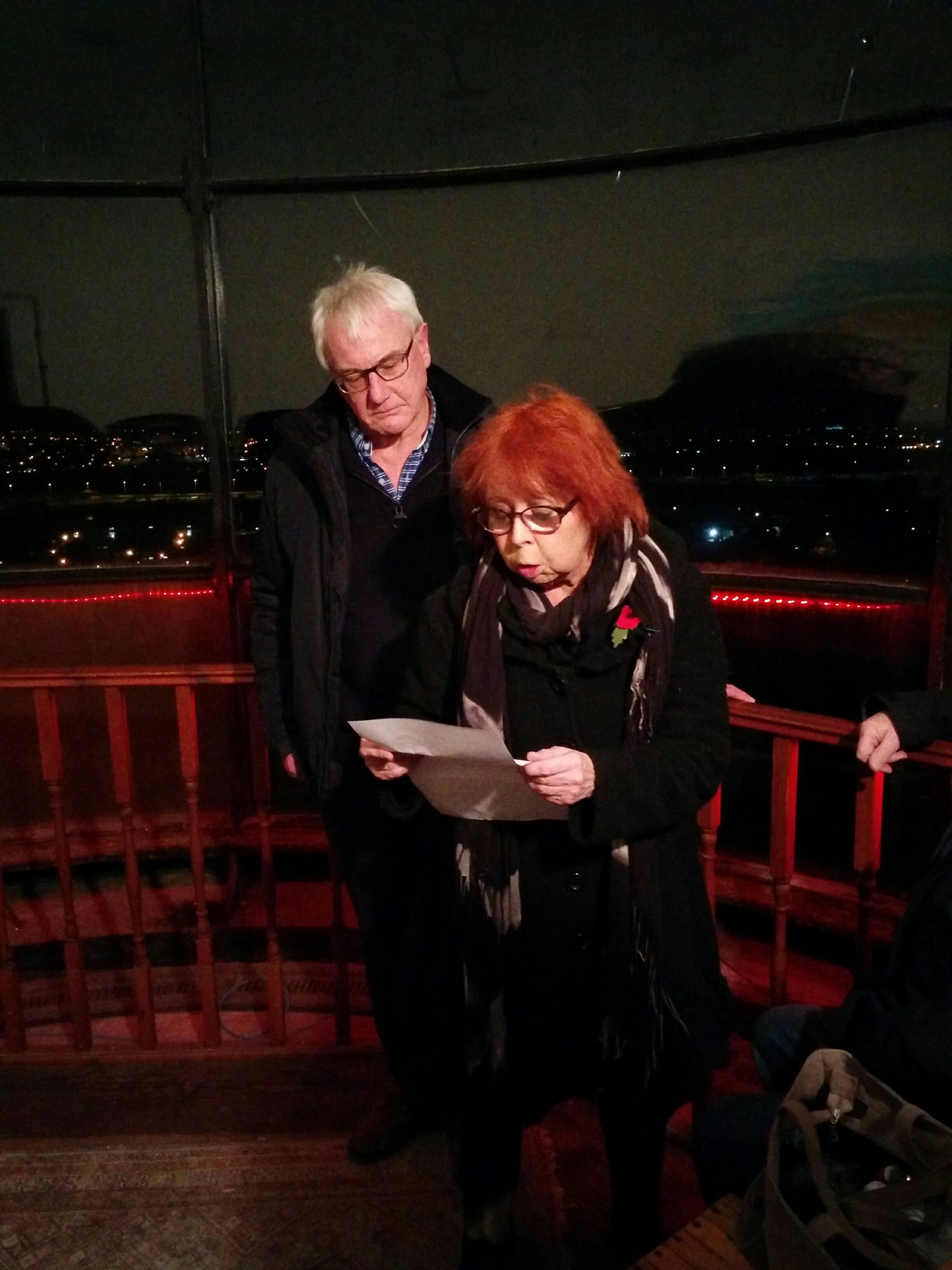 Eileen Willshaw reading from Wilfred Owen. Charlie Warren looks on.